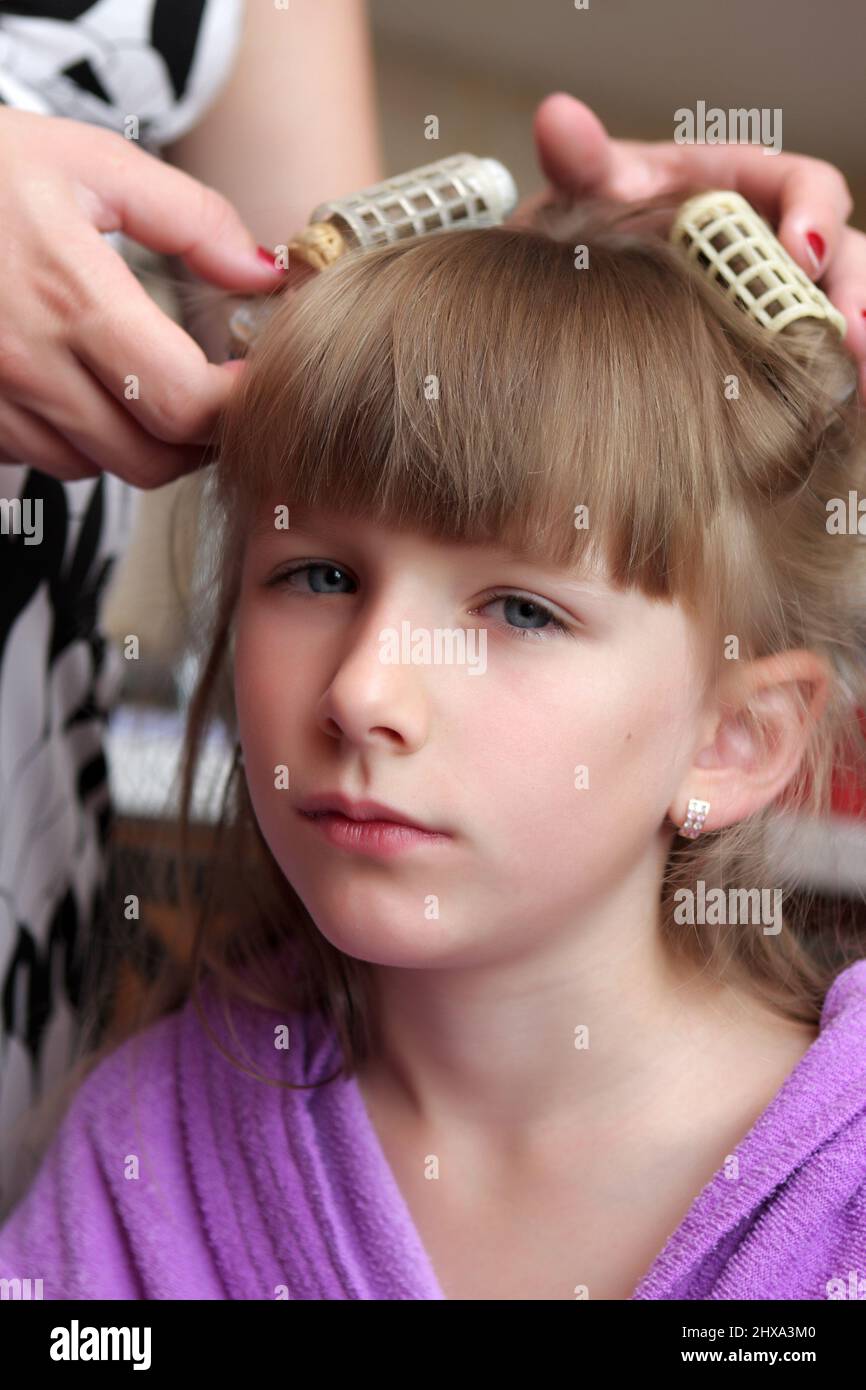A mother winds rollers on her daughter's hair Stock Photo Alamy