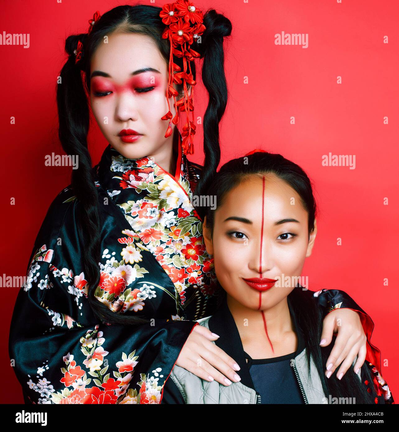 two pretty geisha friends: modern asian woman and traditional wearing ...