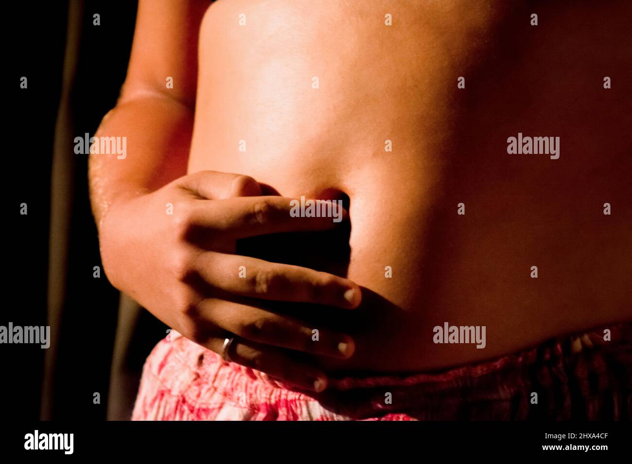hand touching belly button of pregnant woman. Salvador Bahia Brazil. Stock Photo