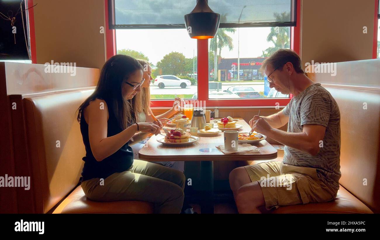 Group of people eating breakfast at a restaurant - MIAMI, UNITED STATES - FEBRUARY 20, 2022 Stock Photo