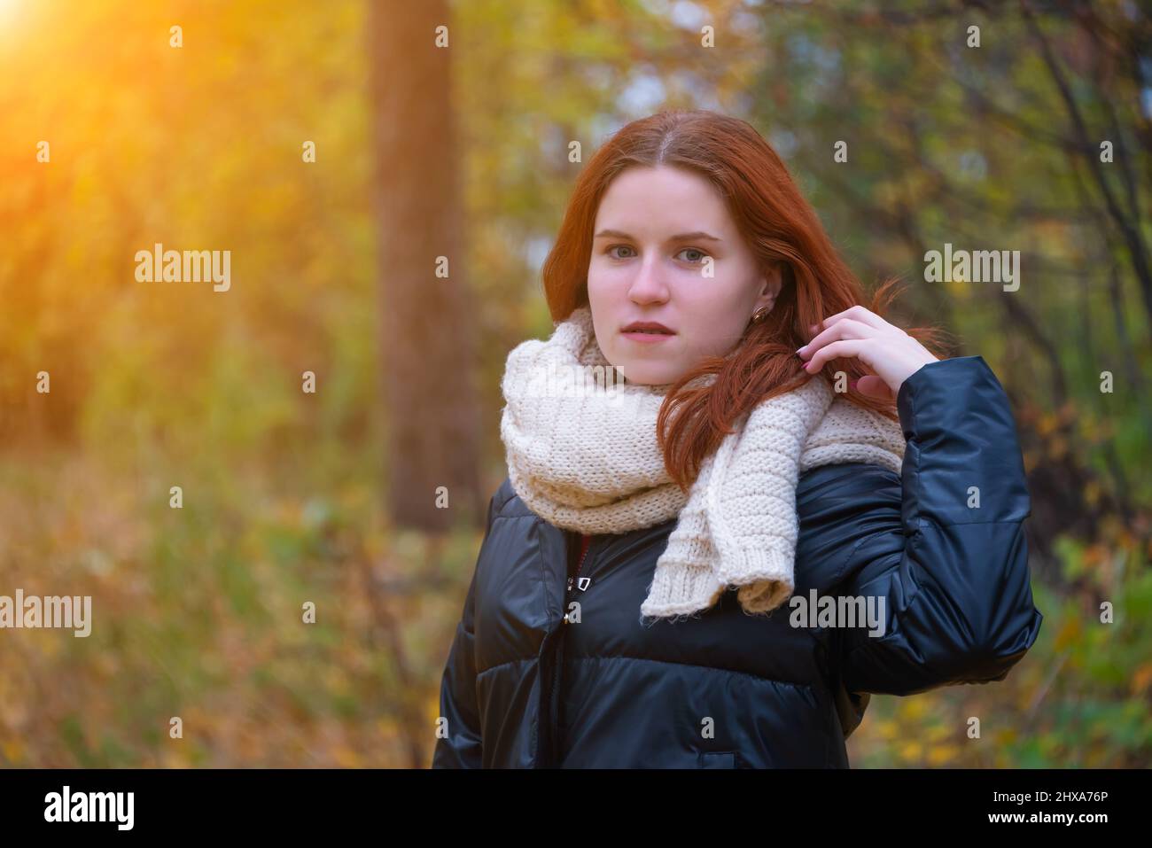 portrait of a red-haired smiling girl in a jacket and scarf ...