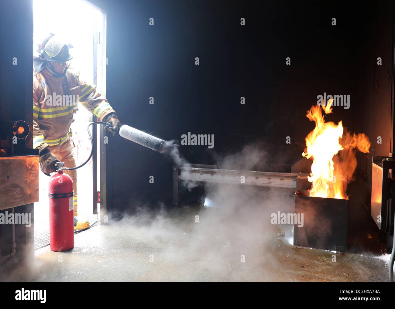 220223-N-OH262-0021--FORT EUSTIS, Va. (February 23, 2022)--A newly hired Civil Service Mariner (CIVMAR) uses a CO2 fire extinguisher to put out a simulated trashcan fire at the Military Sealift Command Training Center East on Joint Base Langley-Fort Eustis, Virginia, Feb. 23. The training was part of the MSC Basic Training Damage Control curriculum, which must be successfully completed prior to sailing in MSC's fleet of ships. (U.S. Navy photo by Bill Mesta/released) Stock Photo