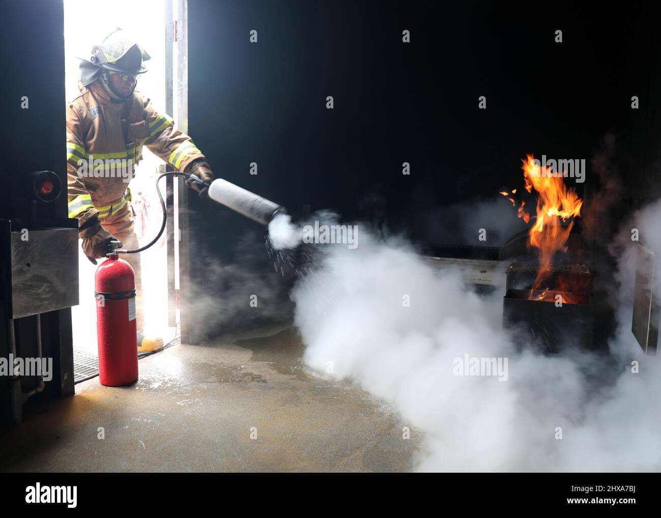 220223-N-OH262-0017--FORT EUSTIS, Va. (February 23, 2022)--A newly hired Civil Service Mariner (CIVMAR) uses a CO2 fire extinguisher to put out a simulated trashcan fire at the Military Sealift Command Training Center East on Joint Base Langley-Fort Eustis, Virginia, Feb. 23. The training was part of the MSC Basic Training Damage Control curriculum, which must be successfully completed prior to sailing in MSC's fleet of ships. (U.S. Navy photo by Bill Mesta/released) Stock Photo