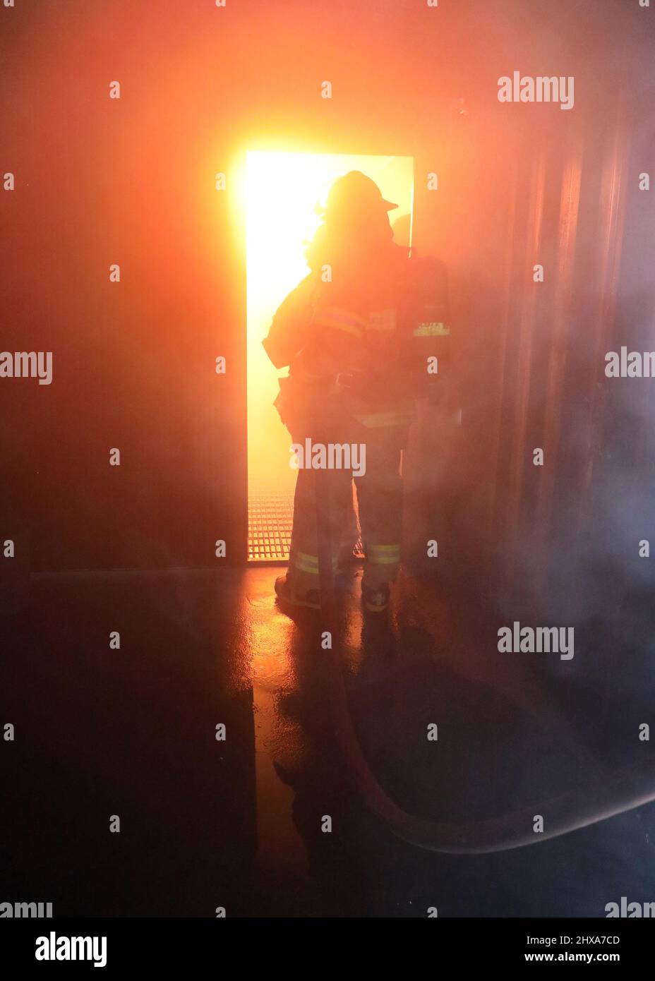 220223-N-OH262-0143--FORT EUSTIS, Va. (February 23, 2022)--Newly hired Civil Service Mariners (CIVMAR) use a fire hose to extinguish a simulated ship's engine room fire at the Military Sealift Command Training Center East on Joint Base Langley-Fort Eustis, Virginia, Feb. 23. The training evolution was part of the MSC Basic Training Damage Control curriculum, which must be successfully completed prior to sailing in MSC's fleet of ships. (U.S. Navy photo by Bill Mesta/released) Stock Photo