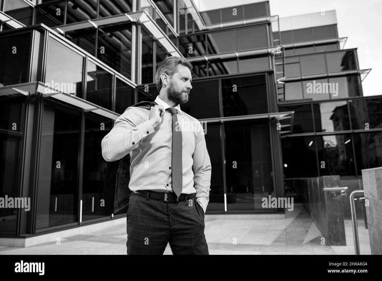 Portrait of a confident mature businessman standing outside office ...