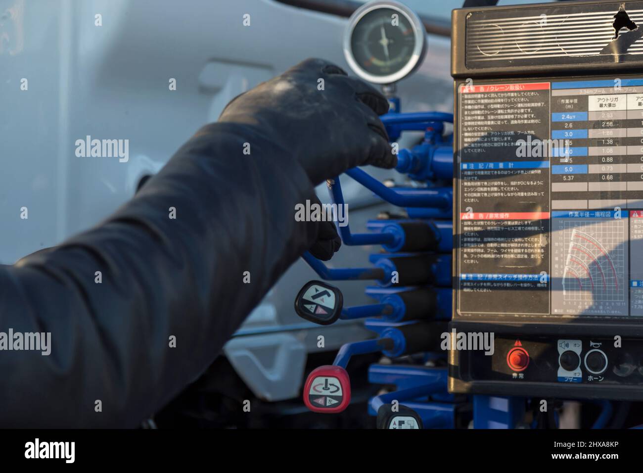 The operator’s hand on the hydraulic crane control levers Stock Photo