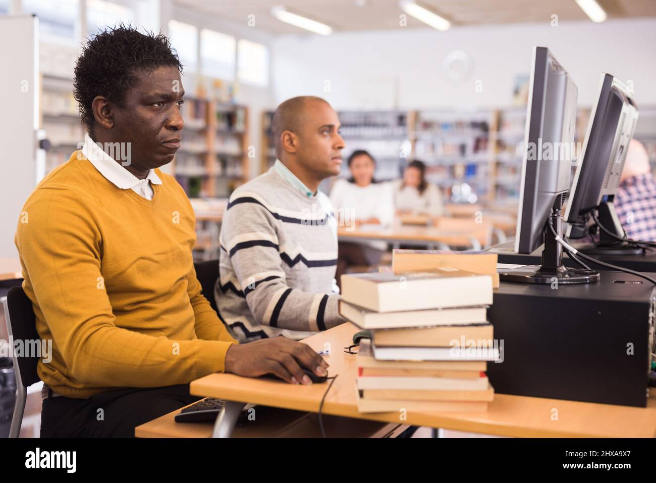 Young adult man studying in computer class Stock Photo - Alamy