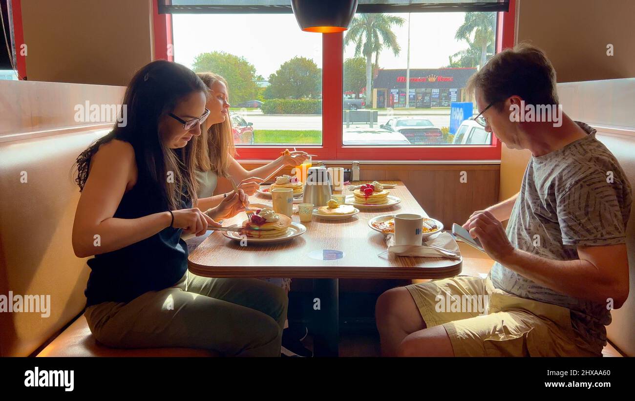 Group of people eating breakfast at a restaurant - MIAMI, UNITED STATES - FEBRUARY 20, 2022 Stock Photo