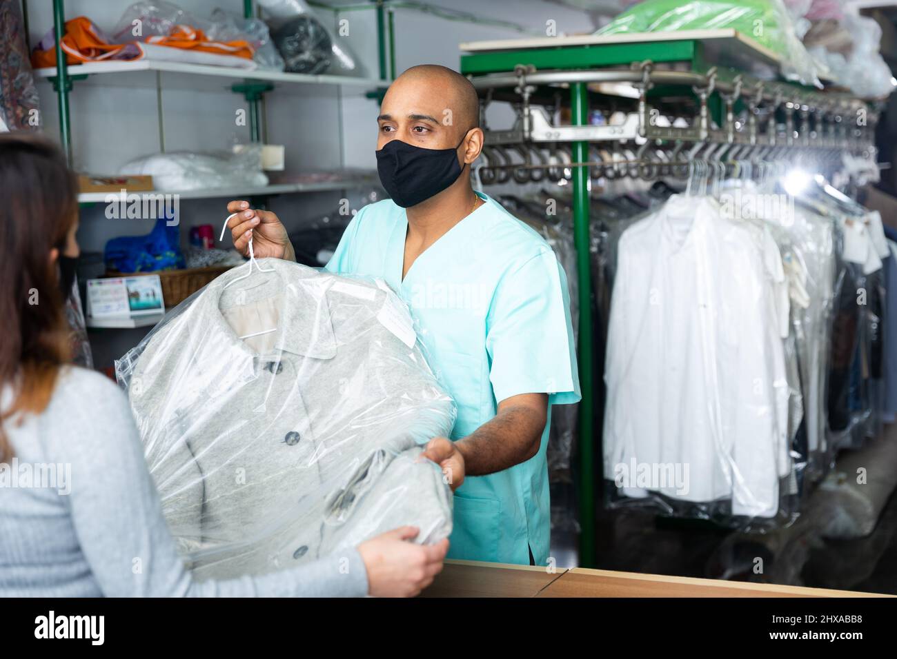 Man drycleaning worker giving clothes to customer Stock Photo Alamy
