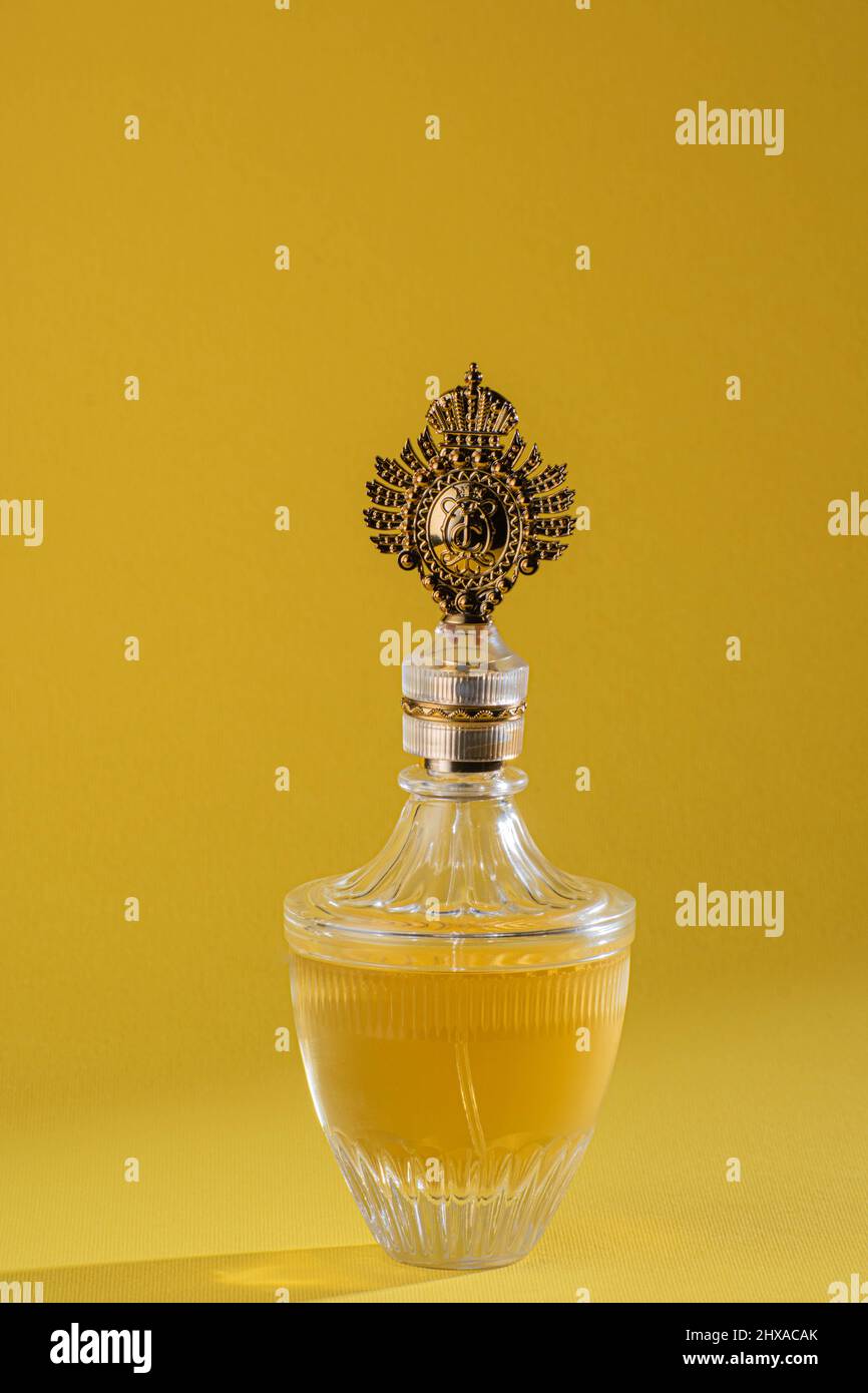 Royal golden french perfume bottle on bright yellow background Stock Photo