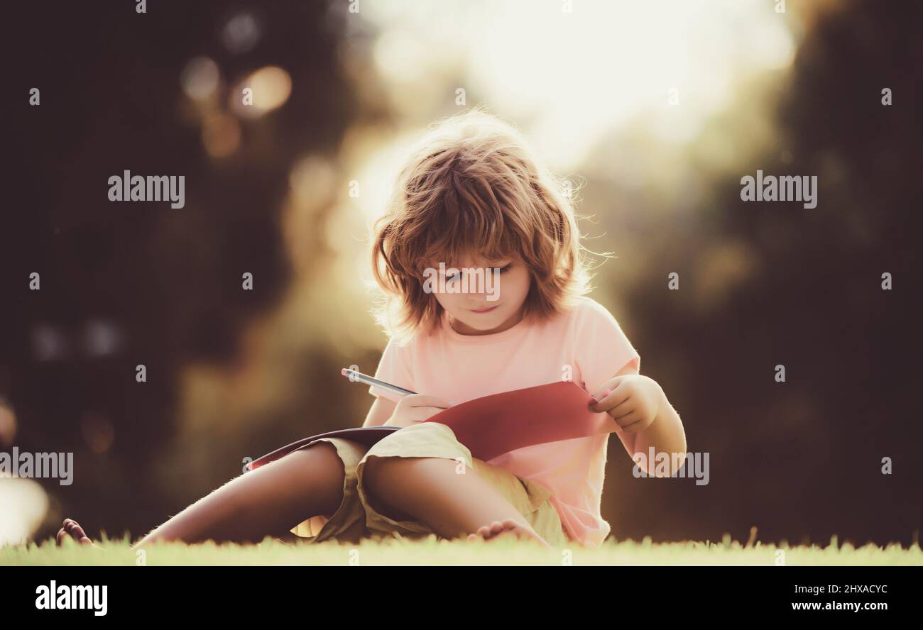 Distance kids learning. Preschool pupil in park on grass Stock Photo ...