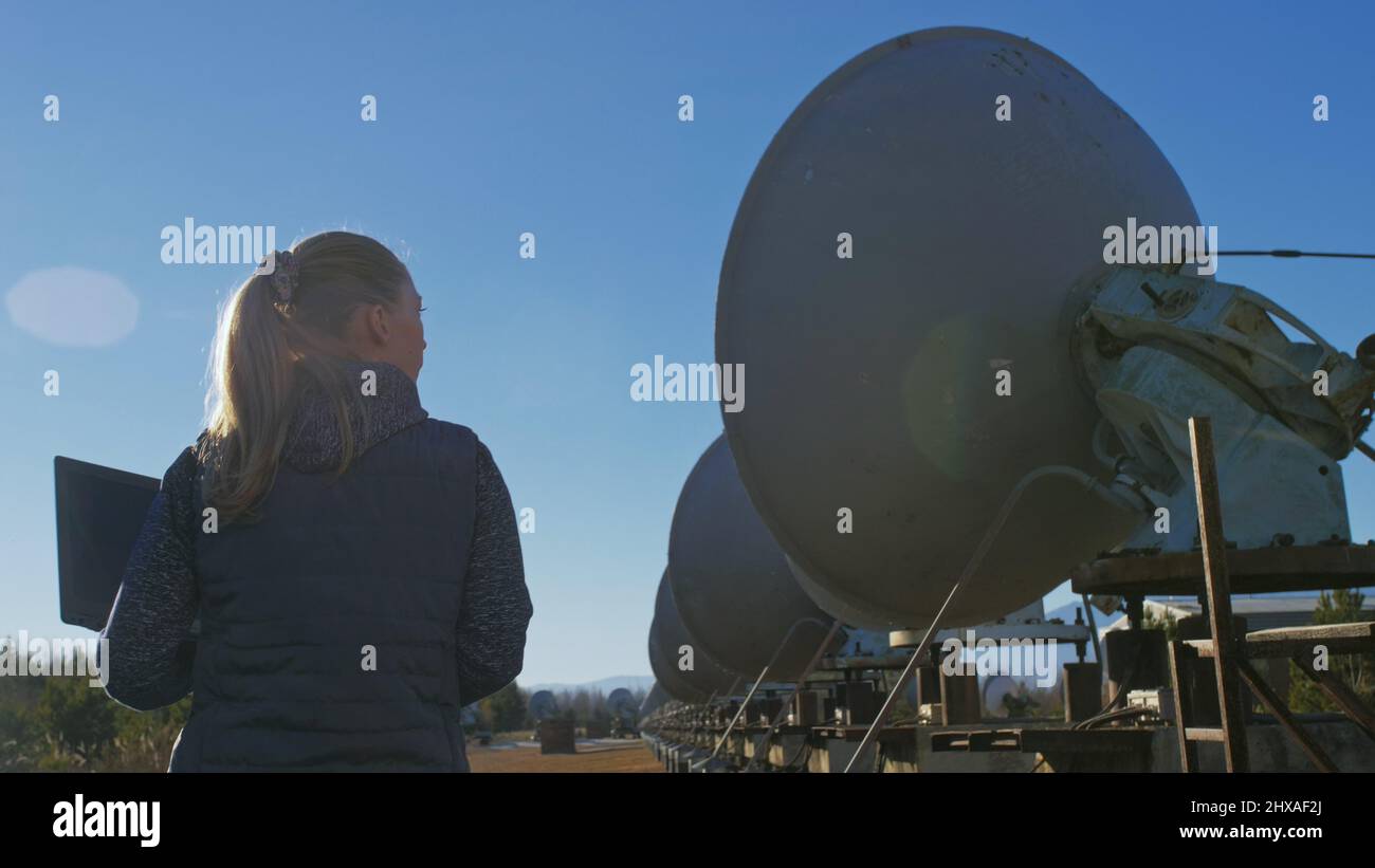 Woman student operator of institute of Solar Terrestrial Physics monitors communication equipment in notebook. Unique array solar radio telescope. Sun Stock Photo