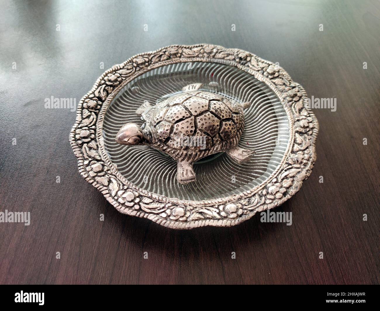 Silver tortoise on a plate for Vastu at home and office. It is believed to bring Prosperity, Good Luck, Good health. The tortoise represents wisdom. Stock Photo