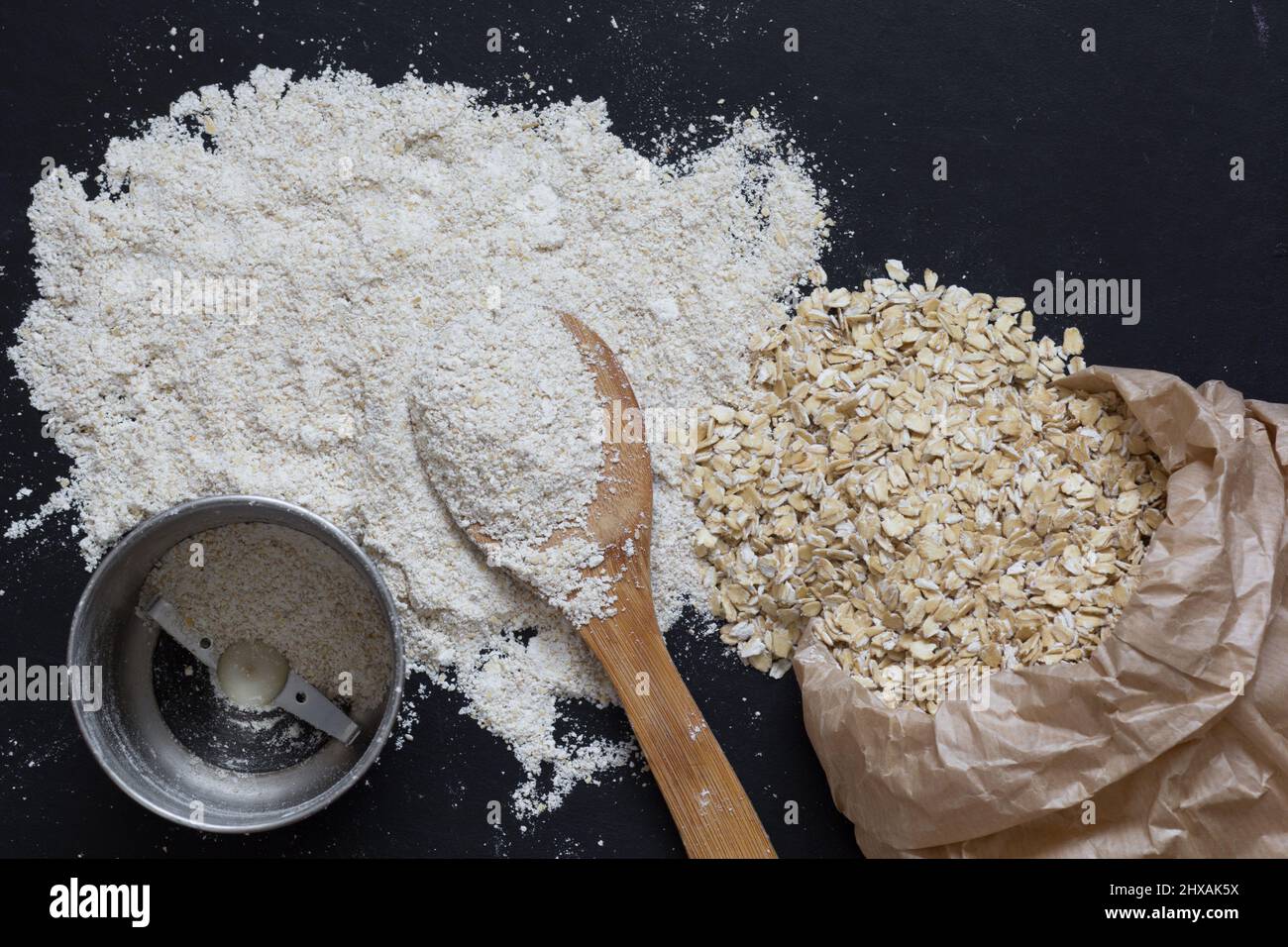 Top view of oats and the coffee grinder for making oat flour on the