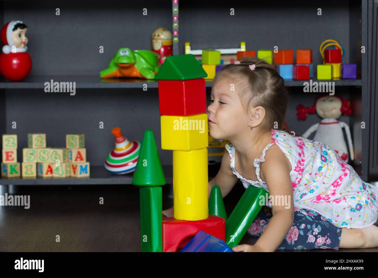 Little girl play with big multicolor plastic blocks Stock Photo - Alamy