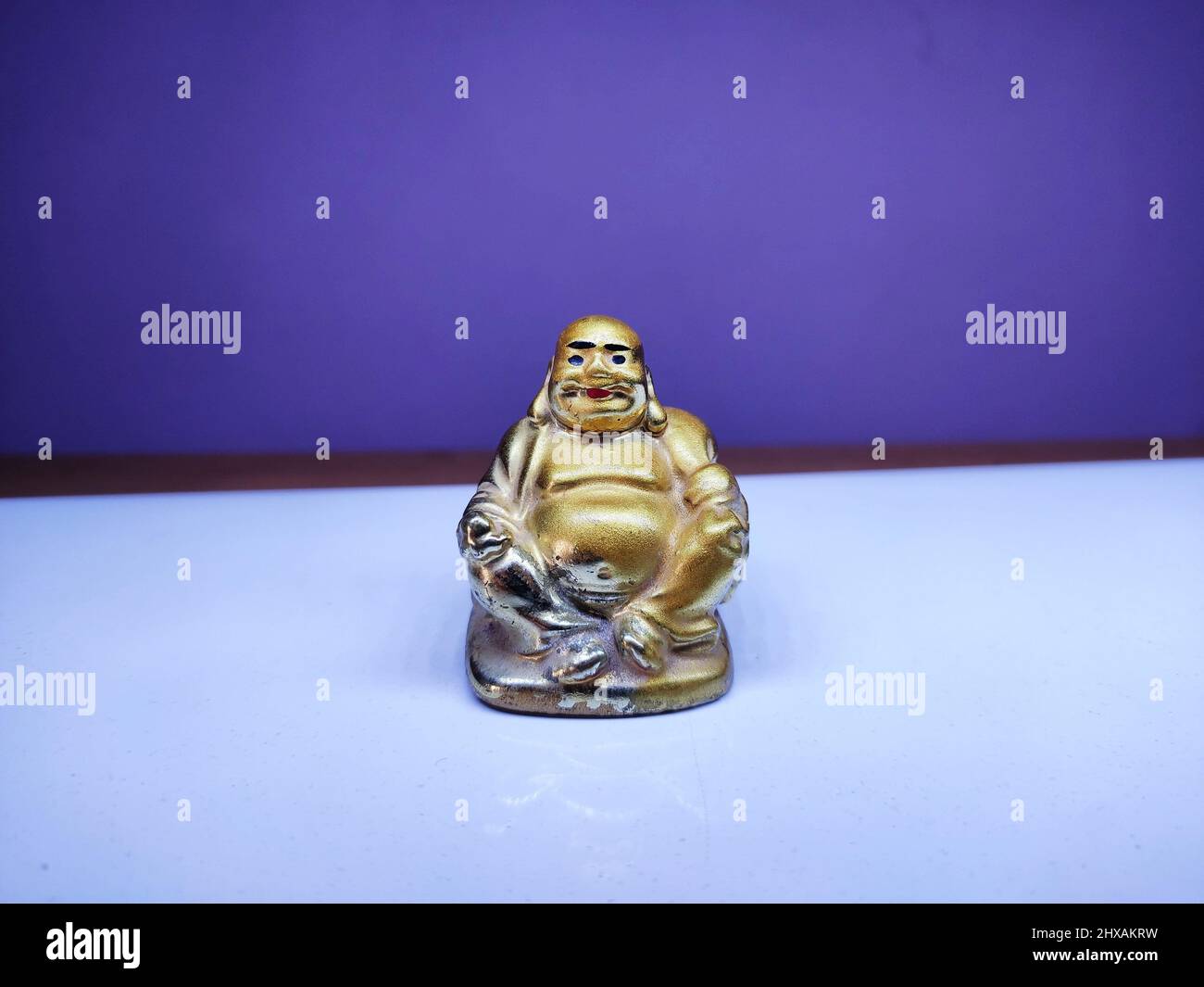 Small and old idol of laughing Buddha  - His large protruding belly is symbolic of happiness, luck and prosperity. Stock Photo