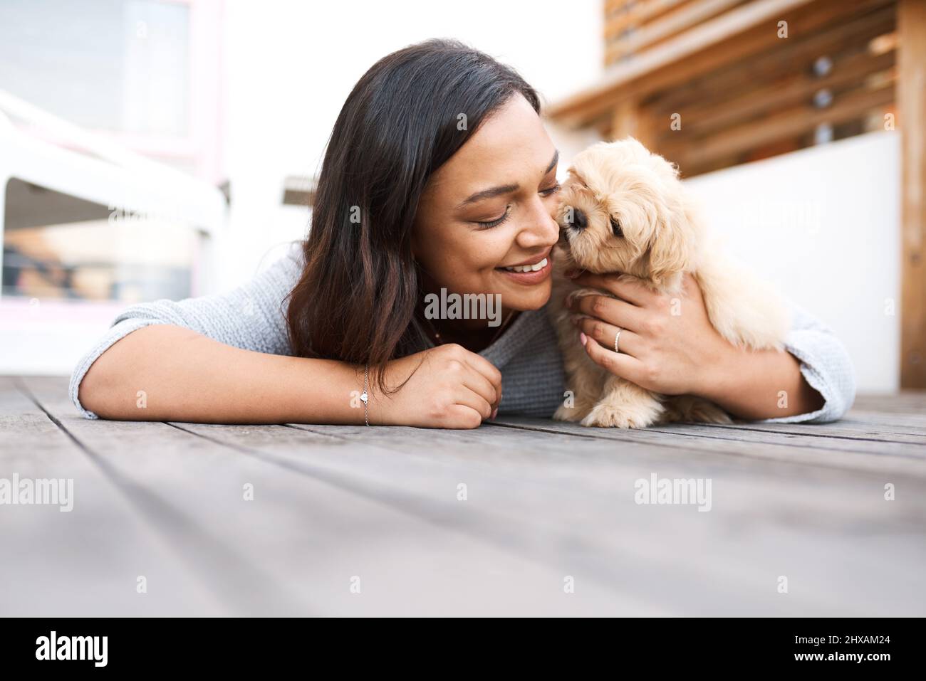 Pets dont see imperfections, only love. Shot of a young woman relaxing with  her dog on a wooden porch outdoors Stock Photo - Alamy