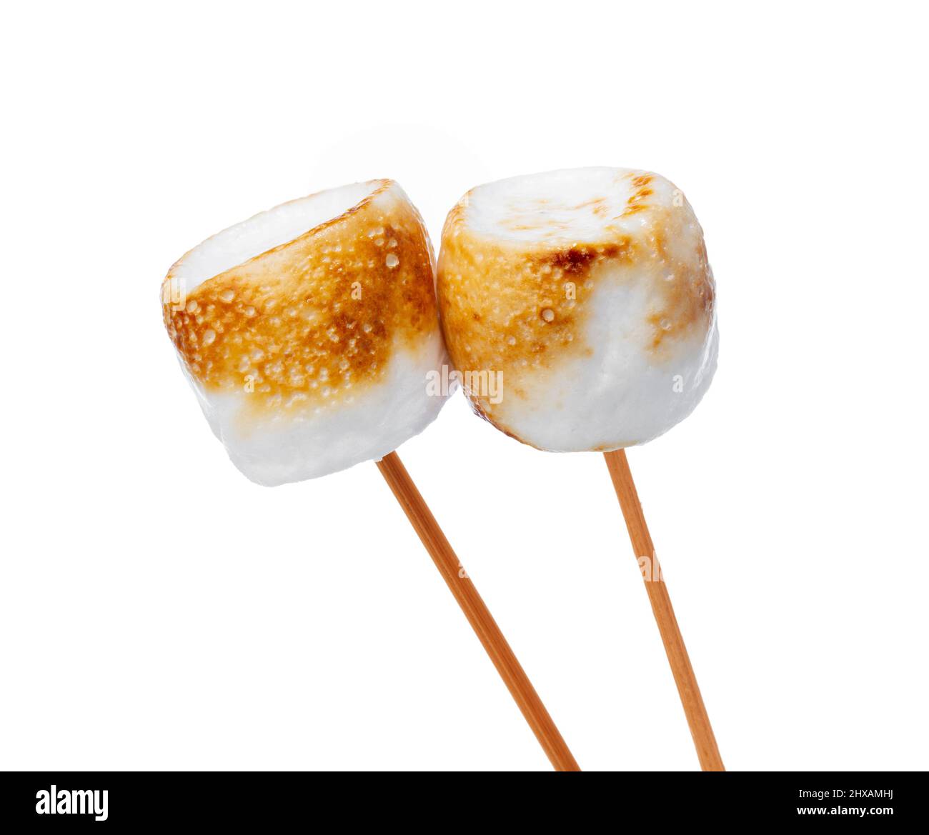 Grilled marshmallows on sticks isolated on white Stock Photo