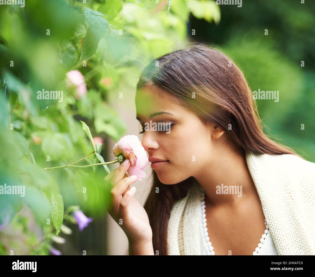 Always stop to smell the roses. Cropped shot of a young woman