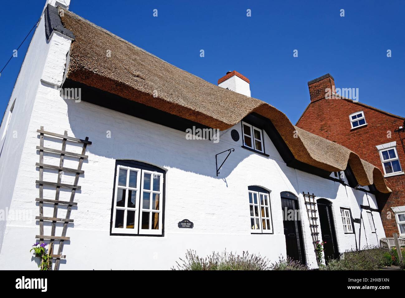 Pretty traditional English whitewashed thatched cottage in the village centre, Kings Bromley, Staffordshire, England, UK, Europe. Stock Photo