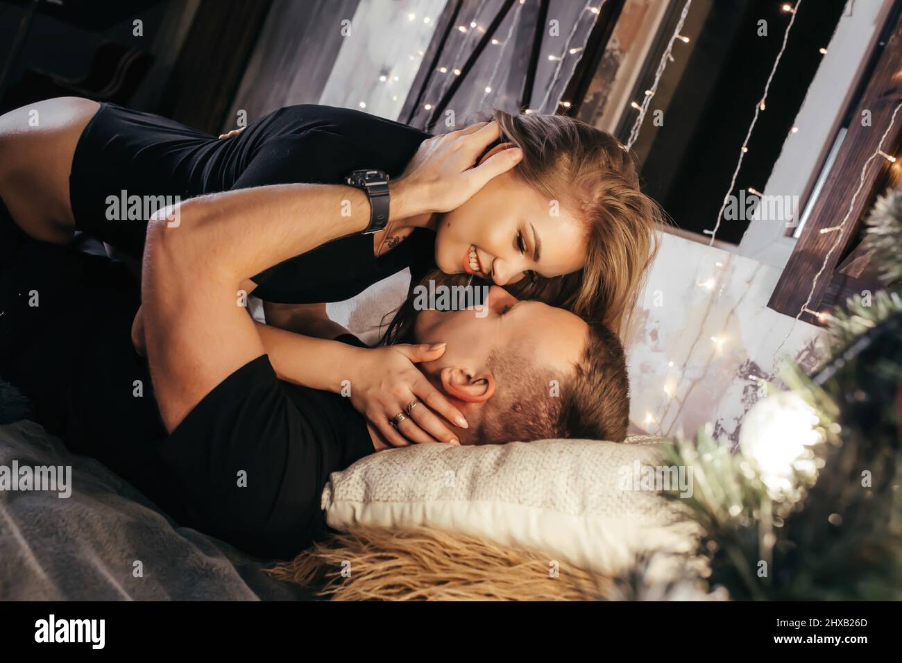 Close up photo of a young couple in an embrace on the bed during New ...
