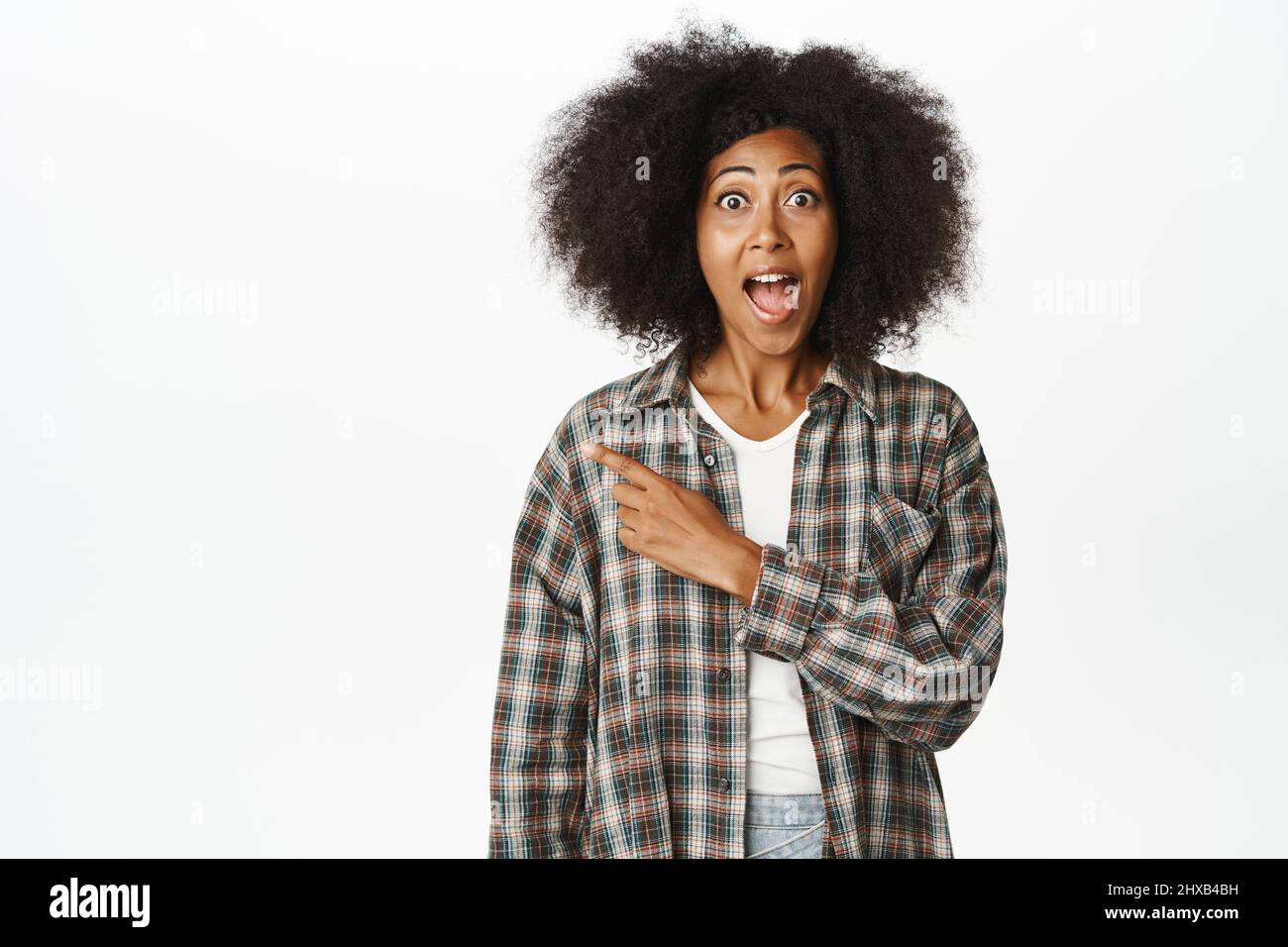 Enthusiastic Black woman pointing left, showing promo information aside ...