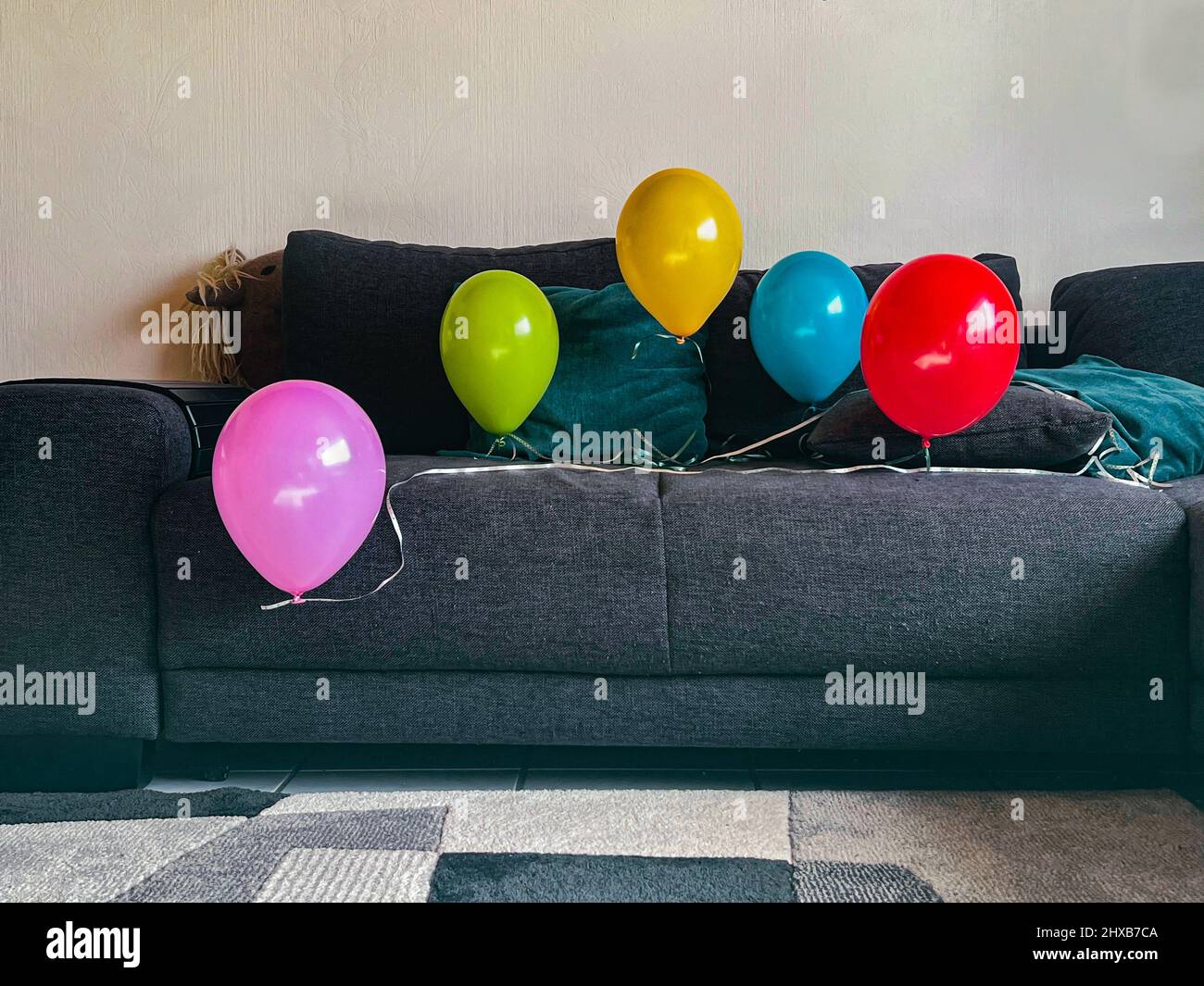 Five balloons on the couch Stock Photo