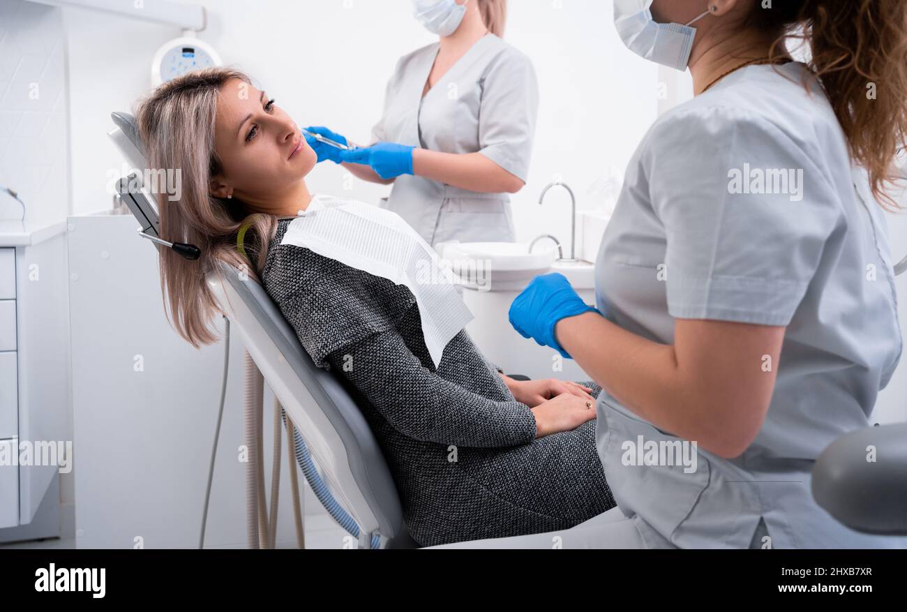 beautiful caucasian girl with toothache sits in a dental chair
