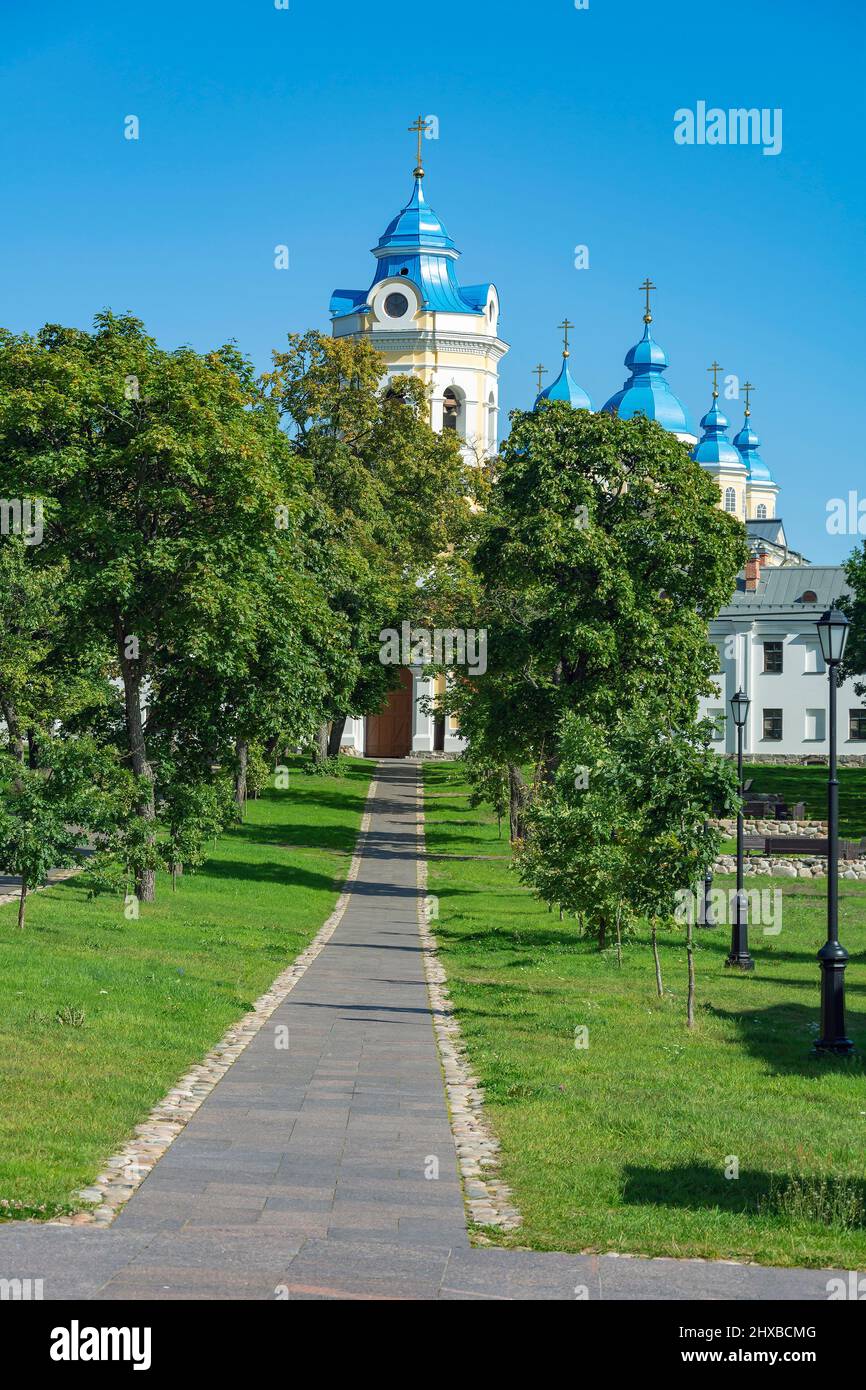 Alley of old trees leading to the buildings of Konevsky Nativity-Bogorodichny Monastery, Konevets Island Stock Photo