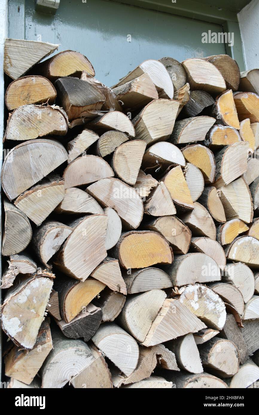 close up cut wood logs, various shapes, stacked and stored outside