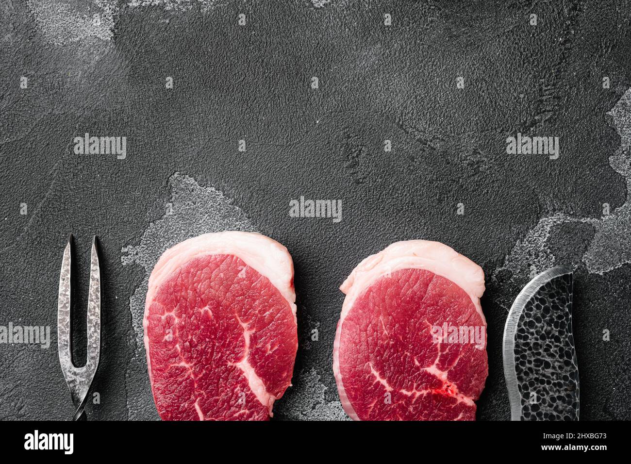 Fresh raw organic beef steak set, on black dark stone table background ...