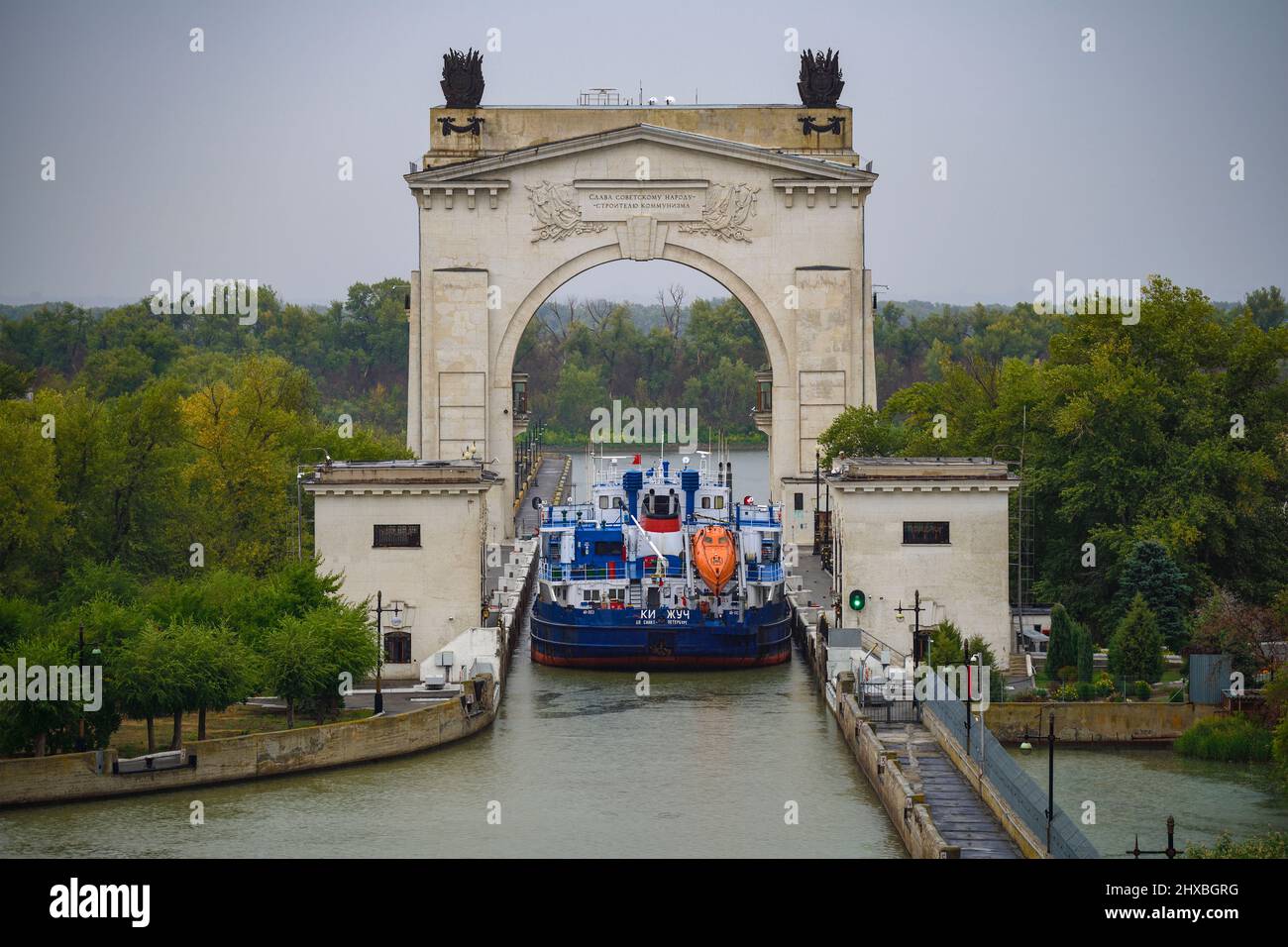 VOLGOGRAD, RUSSIA - SEPTEMBER 20, 2021: A cargo ship passes the first gateway of the Volga-Don Canal on a gloomy rainy day. Stock Photo