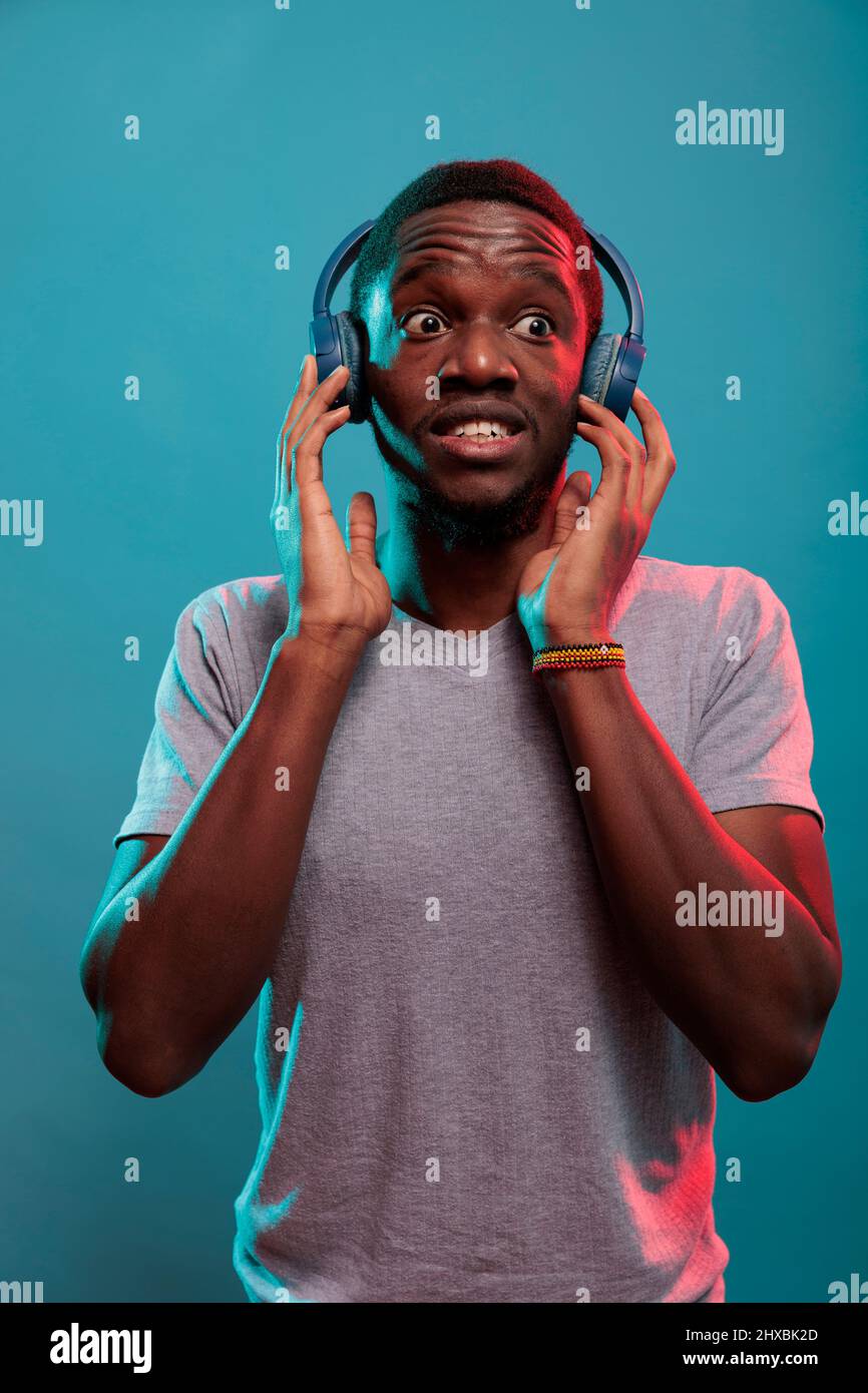 Modern adult being shocked after hearing song on headphones. Young