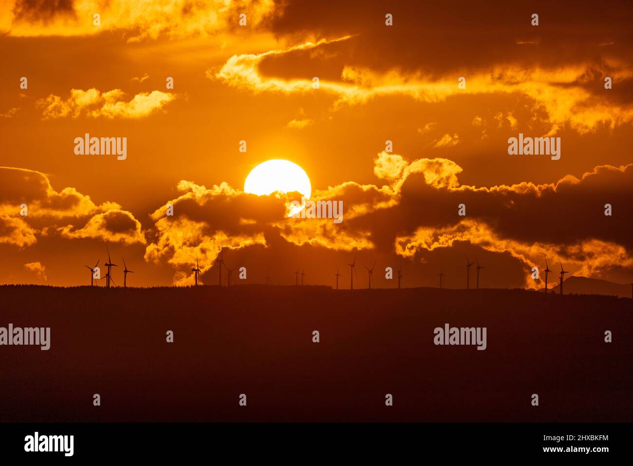 Sunset over wind turbines in the Vale of Clwyd, North Wales Stock Photo