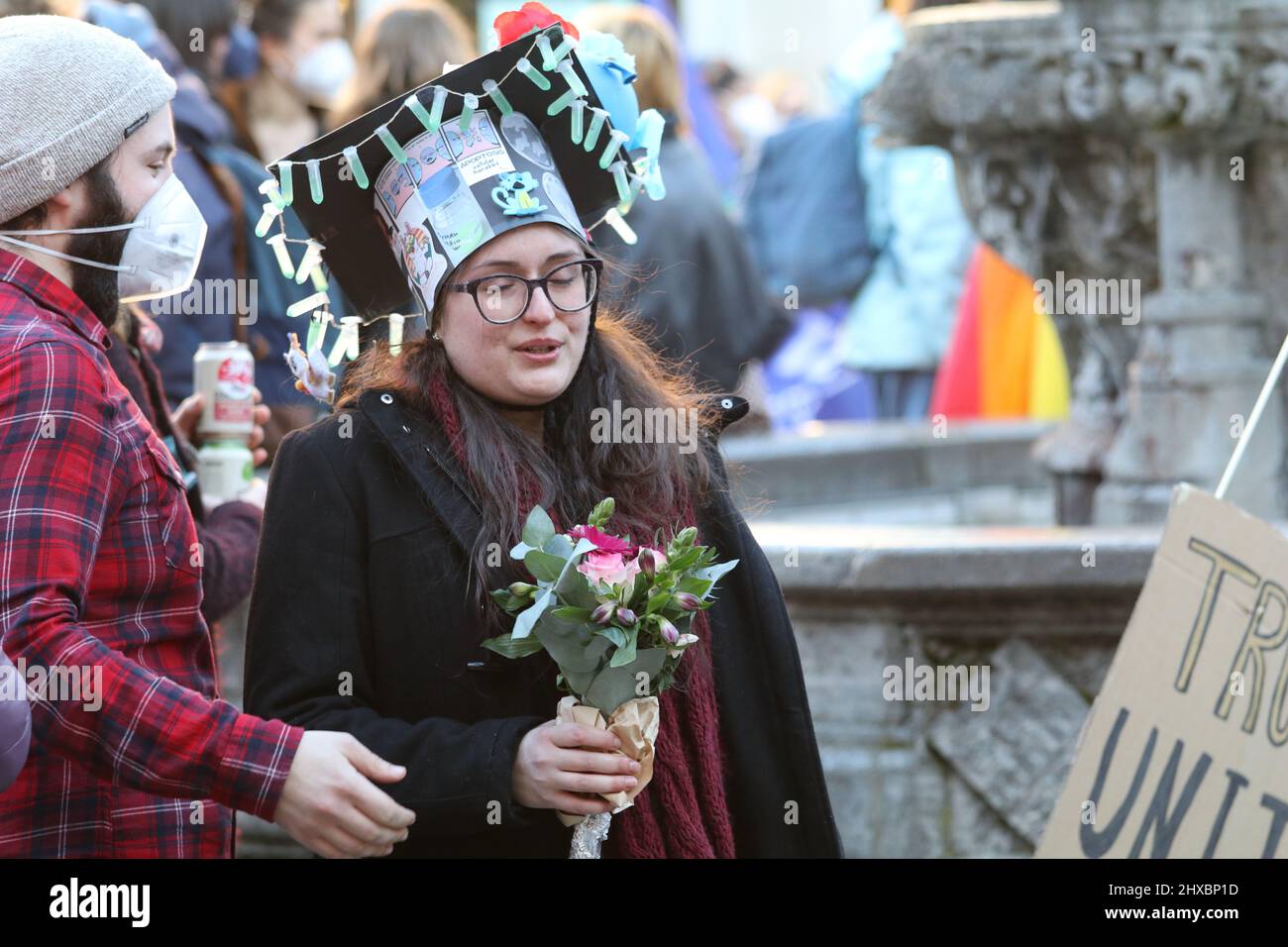 March 8, 2022, GÃ¶ttingen, Lower Saxony, Germany: PhD graduate woman celebrate on GÃ¤nseliesel statue on the occasion of International Women's Day in GÃ¶ttingen, Germany. By tradition PhD graduates climb Gaenseliesel fountain in centeral of GÃ¶ttingen city, kiss the goose girl and give her flowers. (Credit Image: © Tubal Sapkota/Pacific Press via ZUMA Press Wire) Stock Photo