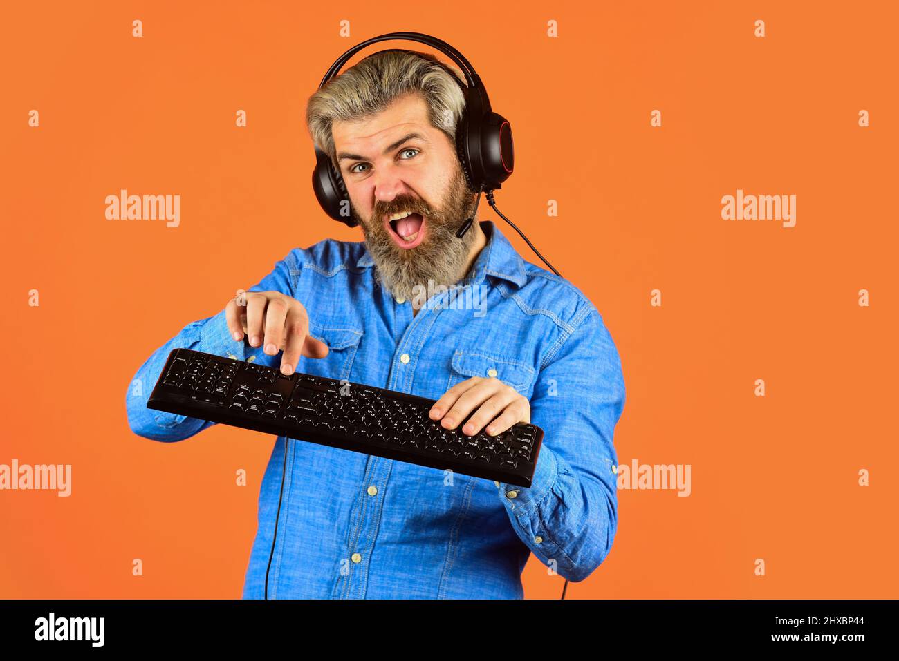 Graphics settings pushed to limit. Play computer games. Man bearded hipster gamer headphones and keyboard. Gaming addiction. Online gaming. Modern Stock Photo