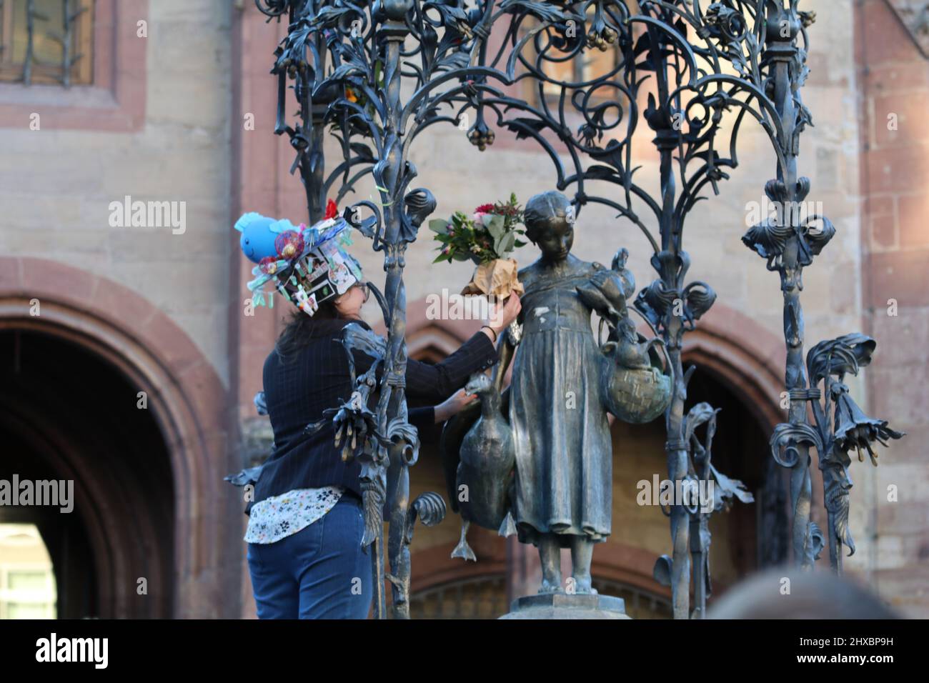 March 8, 2022, GÃ¶ttingen, Lower Saxony, Germany: PhD graduate woman celebrate on GÃ¤nseliesel statue on the occasion of International Women's Day in GÃ¶ttingen, Germany. By tradition PhD graduates climb Gaenseliesel fountain in centeral of GÃ¶ttingen city, kiss the goose girl and give her flowers. (Credit Image: © Tubal Sapkota/Pacific Press via ZUMA Press Wire) Stock Photo