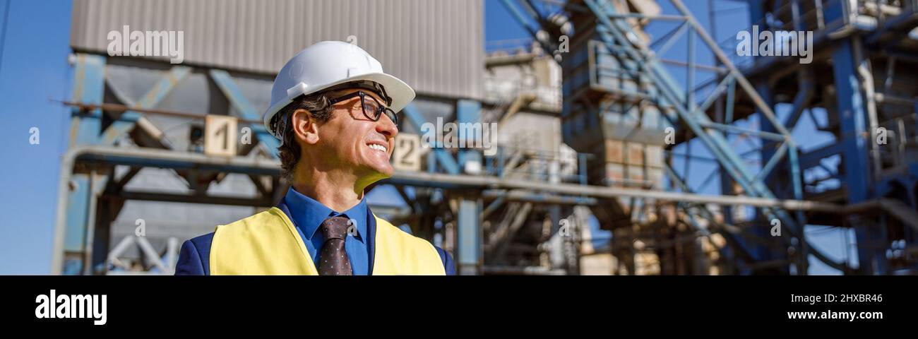 Cheerful male engineer using notebook outdoors at factory Stock Photo ...