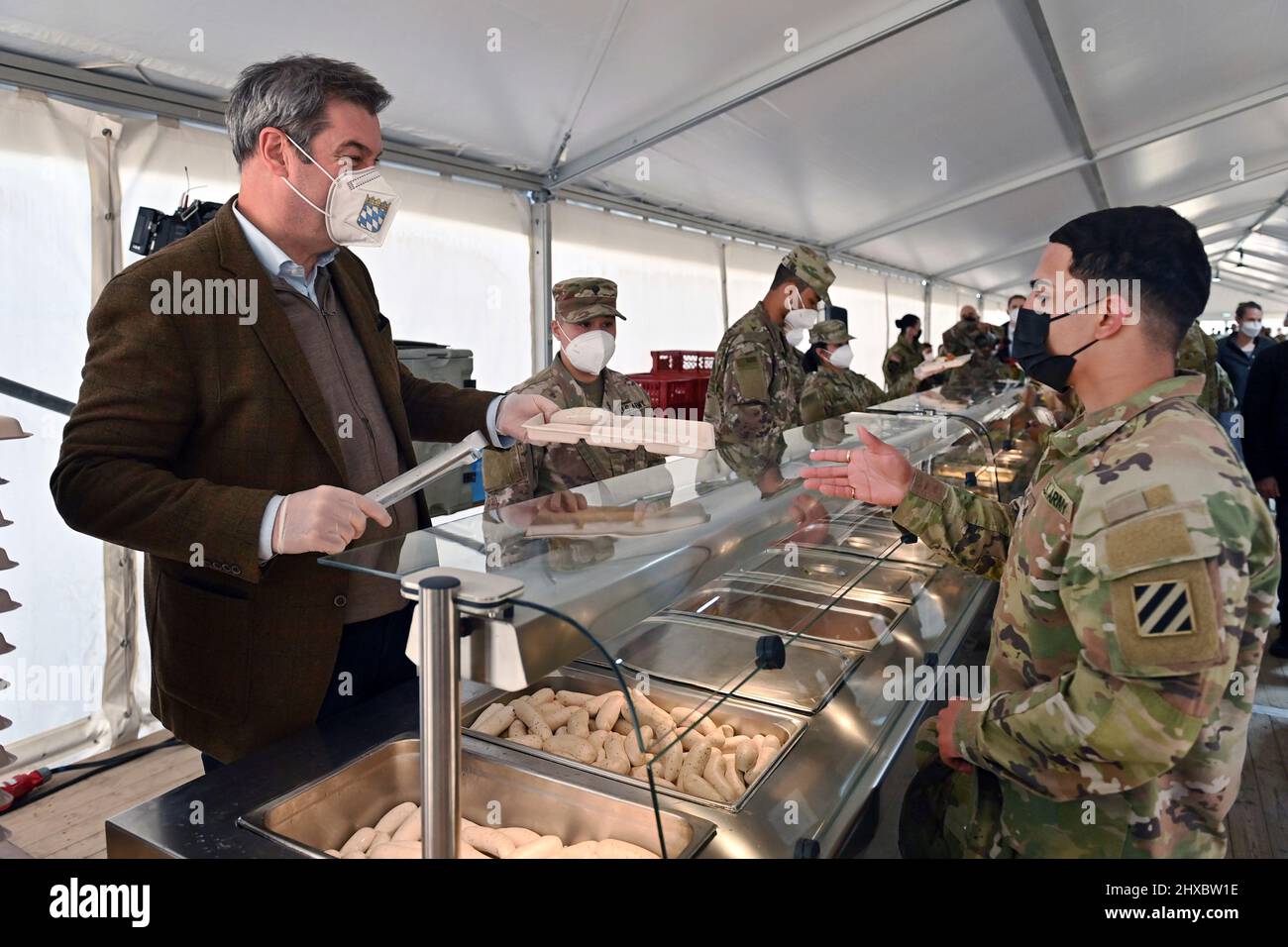 Grafenwoehr, Germany. 11th Mar, 2022. Markus SOEDER (Prime Minister of Bavaria and CSU Chairman) at the food distribution at the Weisswurst counter, Weisswurst Essen.Bavarian Weisswurst breakfast. Prime Minister Dr. Markus Soeder visits the US military training area Grafenwoehr, headquarters of the 7th Army Training Command on March 11th, 2022. Credit: dpa picture alliance/Alamy Live News Stock Photo