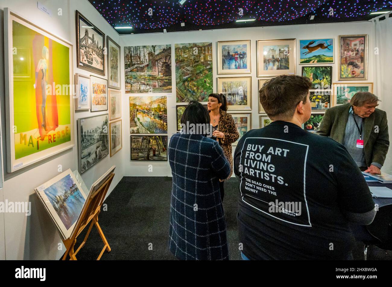 London, UK. 9th Mar, 2022. Buy art from living artists, on a visitors t-shirt - The Affordable Art Fair returns to Battersea Park and runs until Sunday 13 March. The fair offers visitors a chance to purchase work from over 100 local and international galleries at prices between £50 and £7,500. Credit: Guy Bell/Alamy Live News Stock Photo