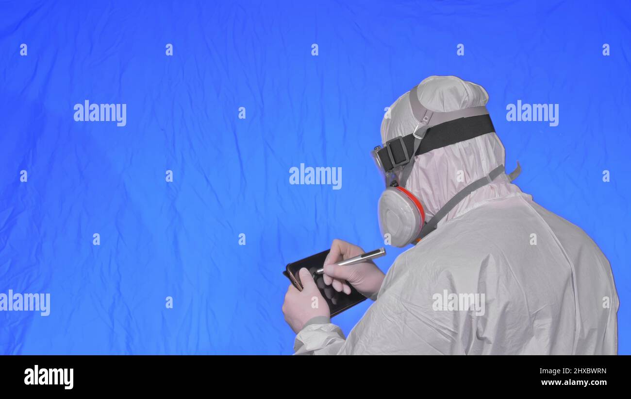 Scientist virologist in respirator makes write in an tablet computer