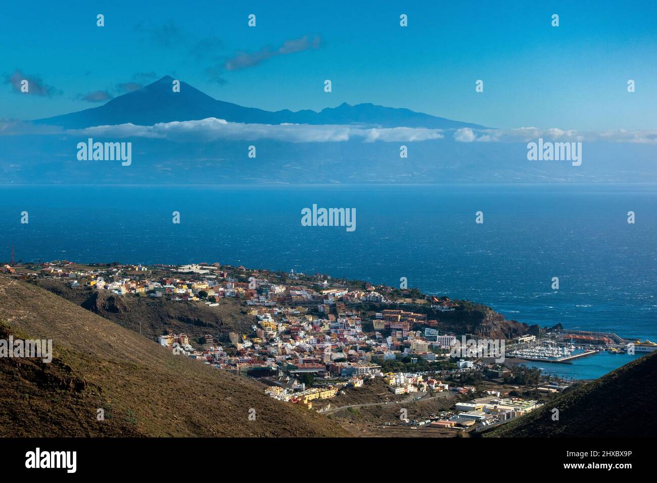 View from La Gomera showing the town of San Sebastian in the foreground and Mount Teide volcano on Tenerife in the distance. Canary Islands, Spain Stock Photo