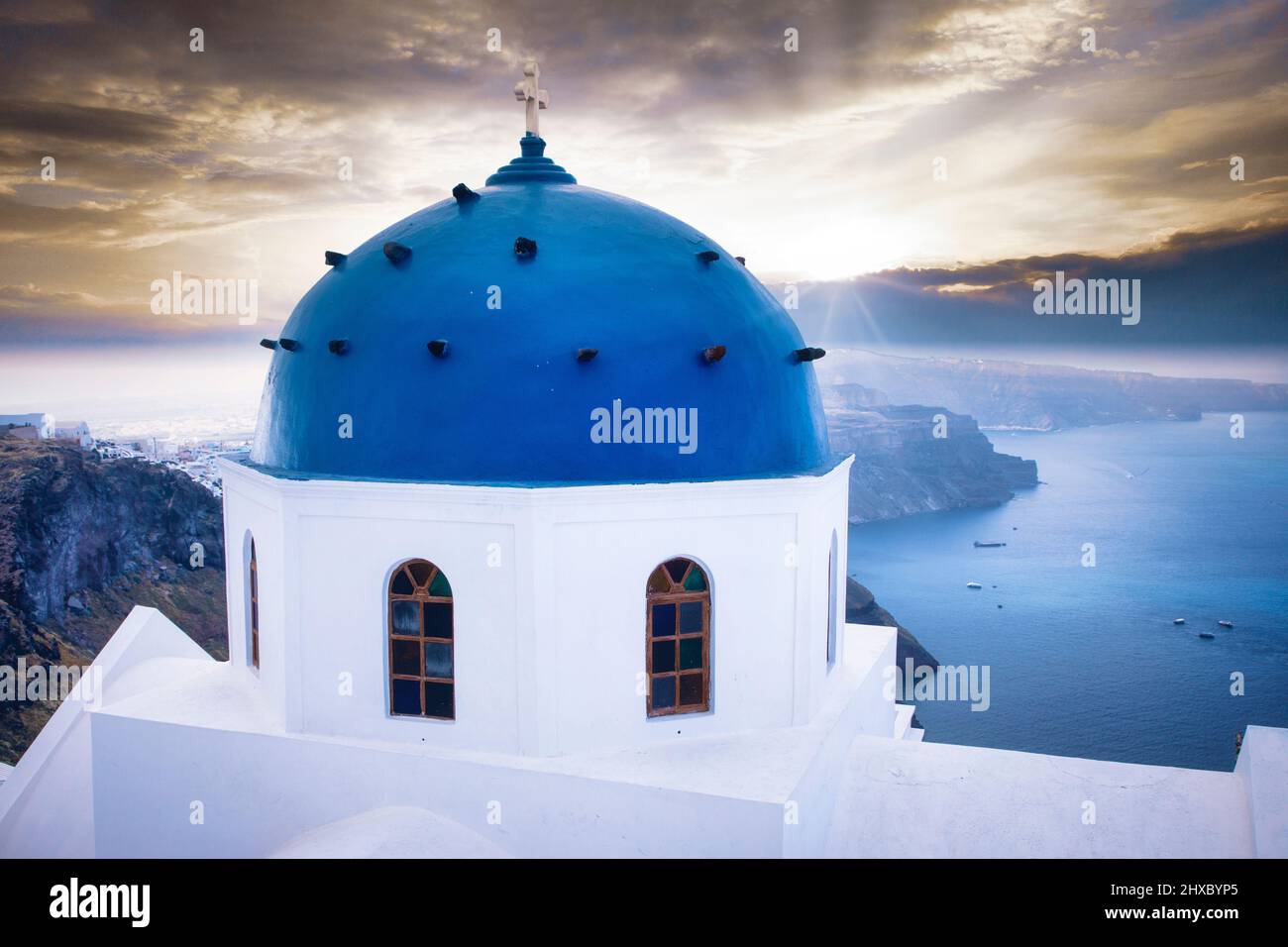 A church dome in Imerovigli overlooks the Aegean Sea from the caldera cliffs of Santorini, Greece. Stock Photo