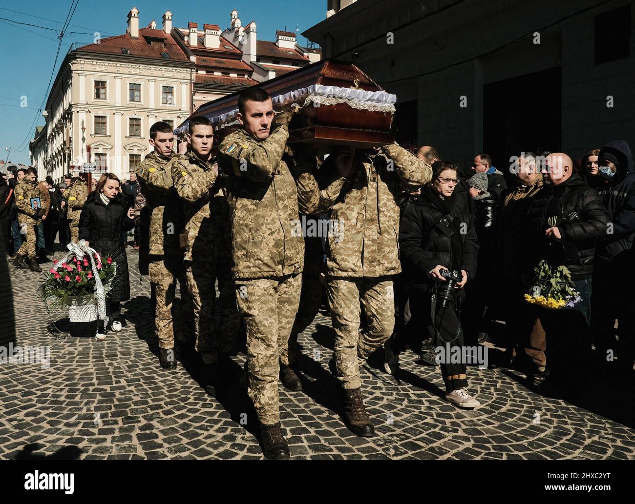 Ukrainian soldiers carry the coffins of their comrades from the church