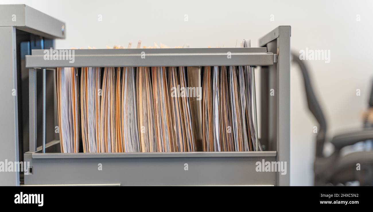 Hanging files in filling cabinet in an office at work Stock Photo