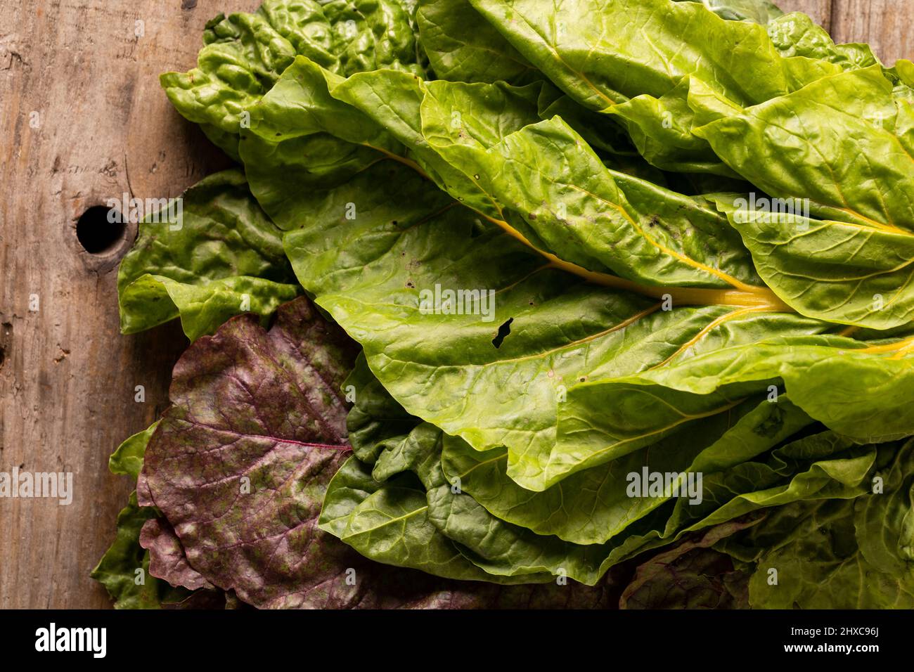 Directly above close-up shot of fresh leaf vegetable on wooden table Stock Photo