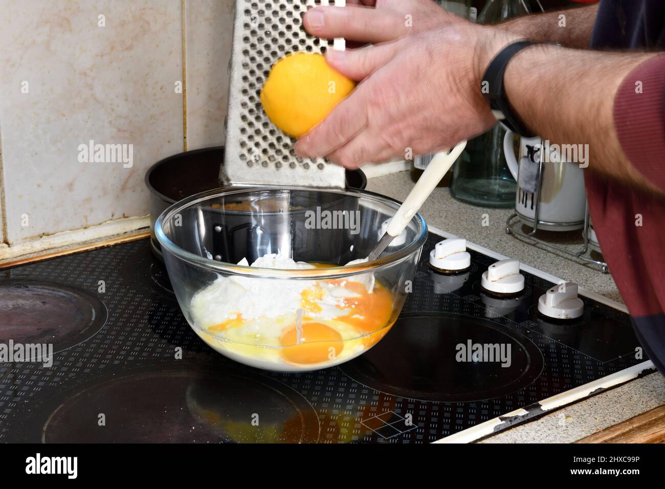 Step 6 Using Grater to add Lemon (Citrus limon) Zest to the mixture Hook Norton Oxfordshire England uk Stock Photo