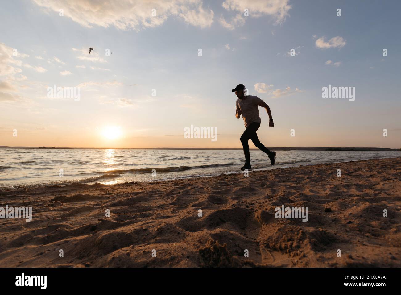 Young man running at waterfront hi-res stock photography and images - Alamy