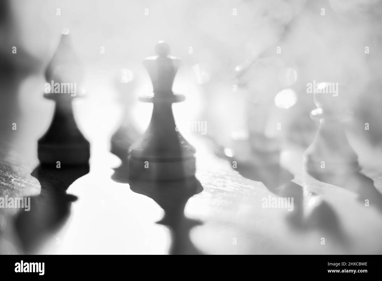 Silhouettes of chess pieces in the smoke of war. Black and white image. Abstraction of the battle strategy. Business. Stock Photo