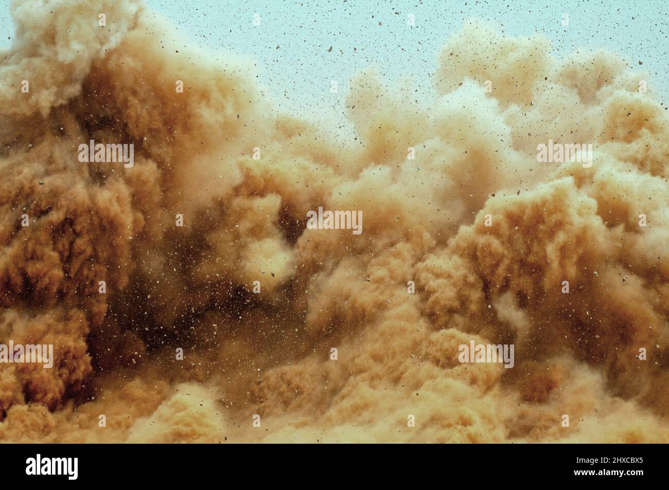 Rock particles and dust storm during denotator blast on the mining site Stock Photo